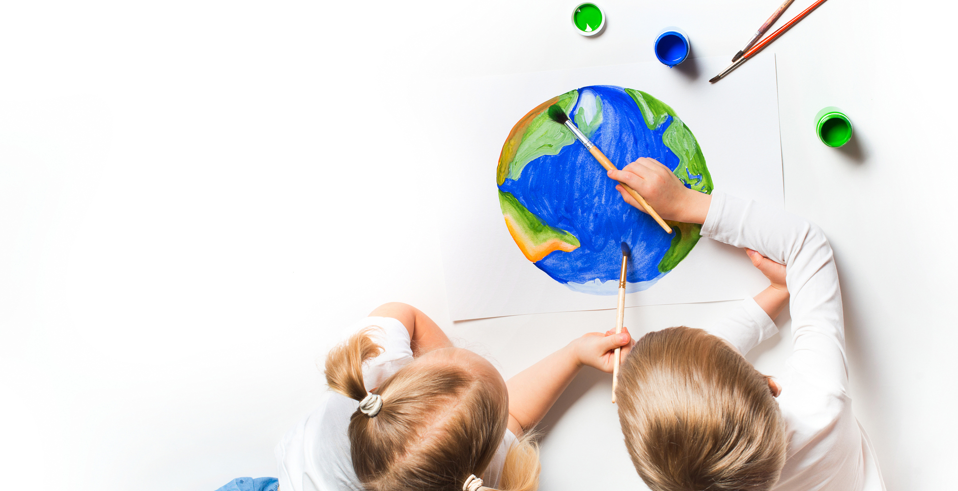 Ecology concept with two prety little kids painting earth on whi